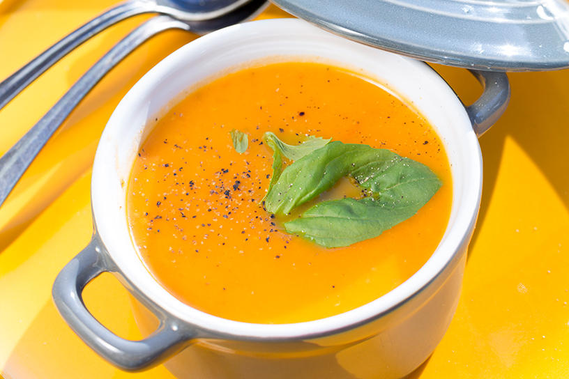 gele tomatensoep met basilicum in soepkom